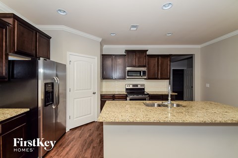 a kitchen with a granite counter top and a stainless steel refrigerator