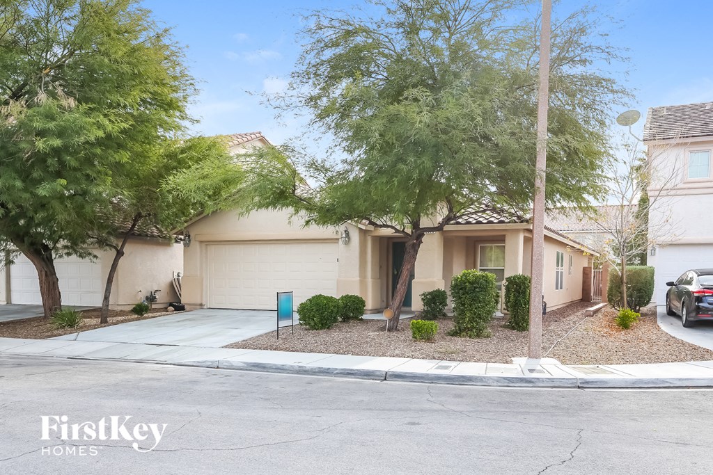 a house with a driveway and trees in front of it