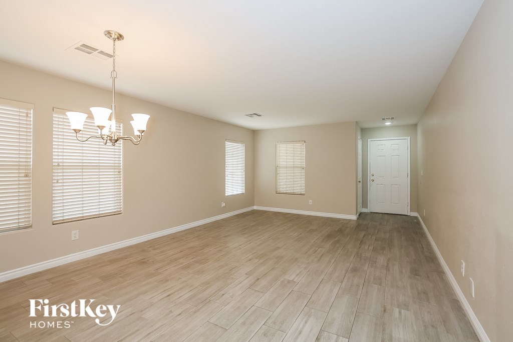 a spacious dining room with wood flooring and a white door