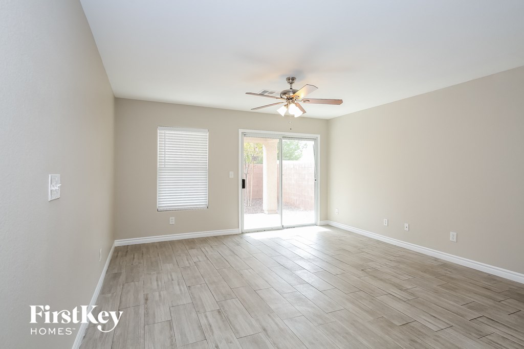 a living room with a ceiling fan and a sliding glass door