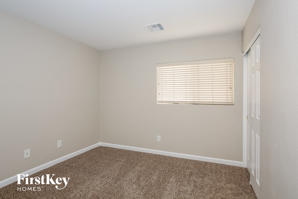 a empty room with carpet and a window