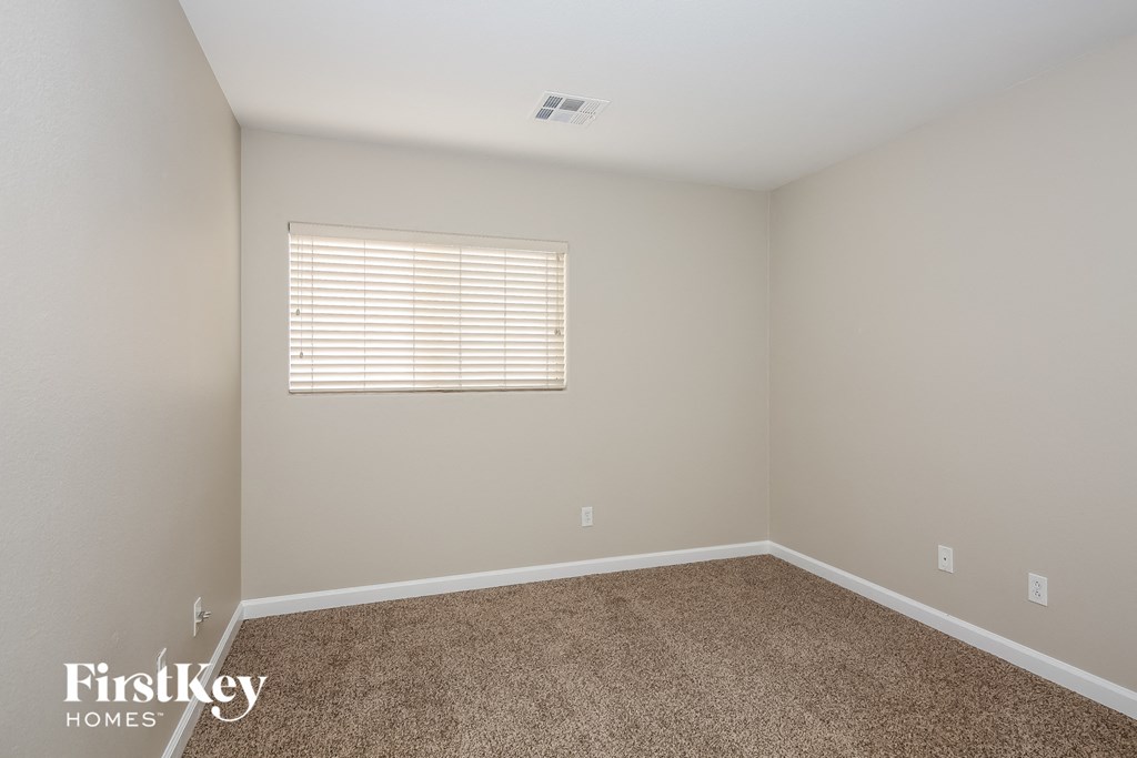 a empty room with carpet and a window