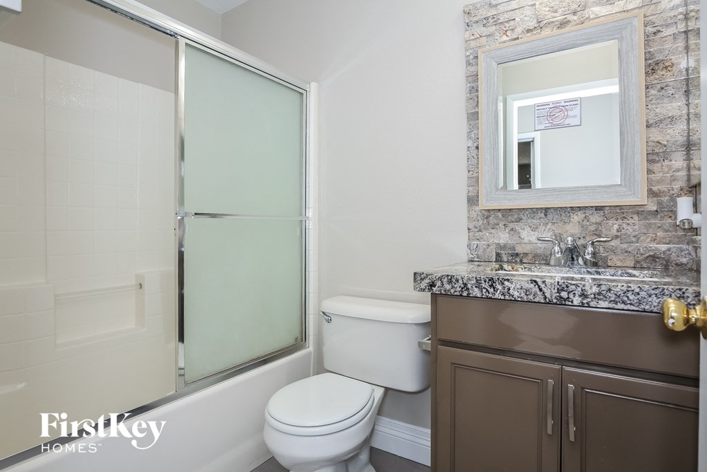 a bathroom with a toilet and a shower and a sink