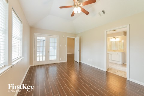 the living room with wood flooring and a ceiling fan