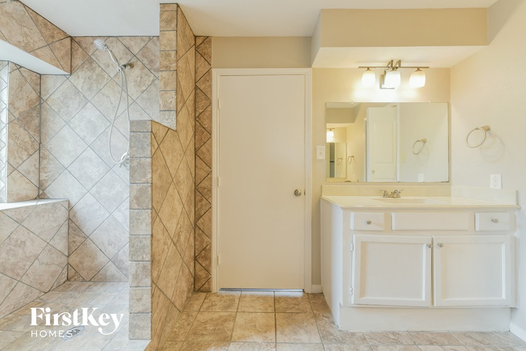 a bathroom with a shower and a sink and a mirror