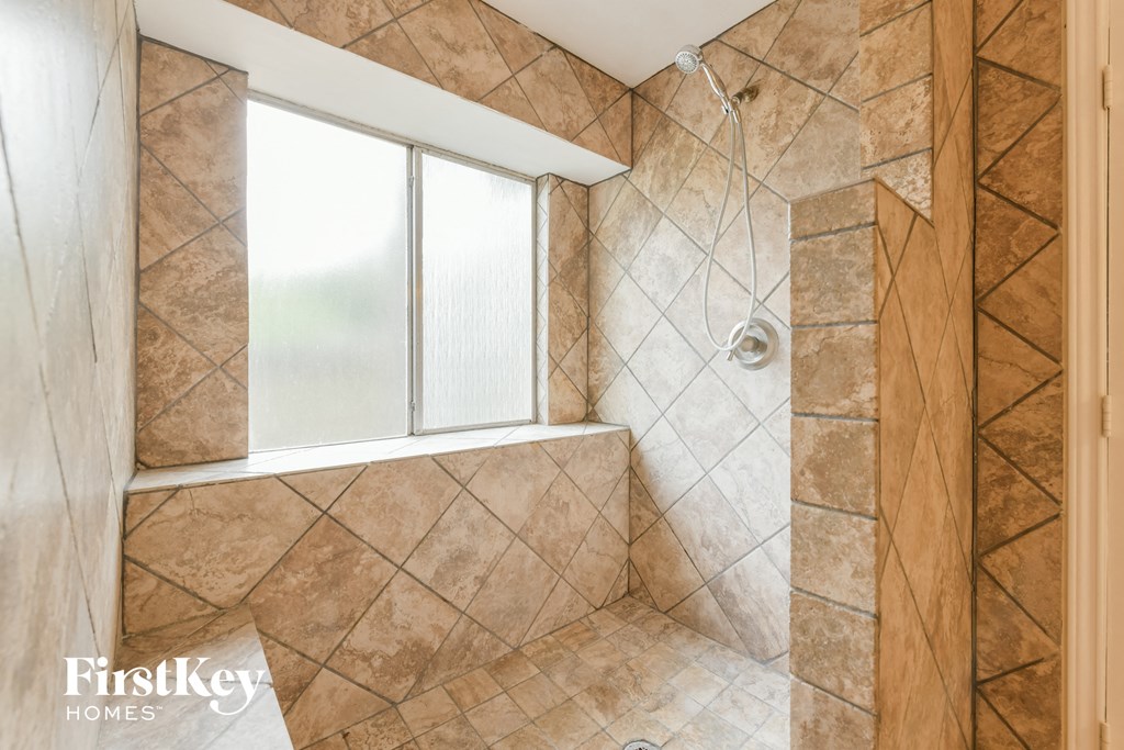 a large bathroom with a shower and a window