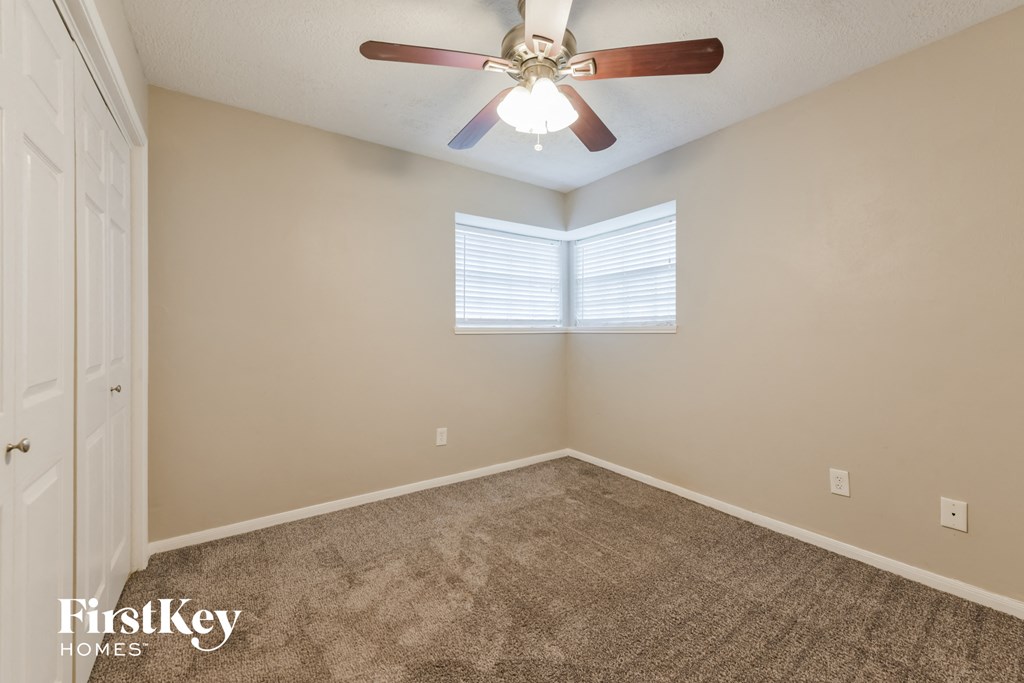 the master bedroom has a ceiling fan and carpeted flooring