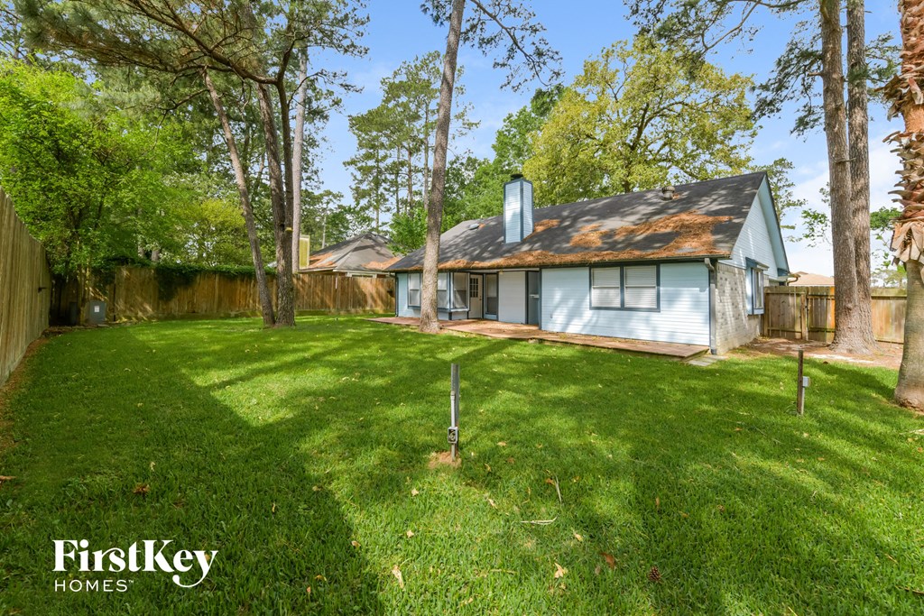 a backyard with a blue house and a yard with trees