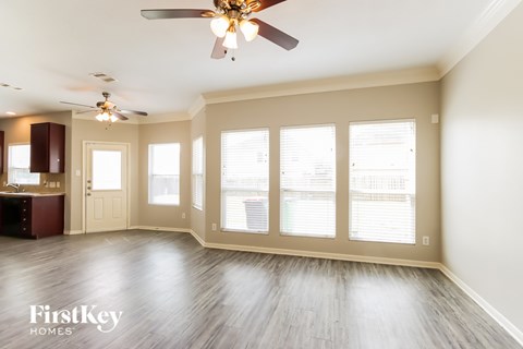 A spacious room with a ceiling fan and sliding glass doors.