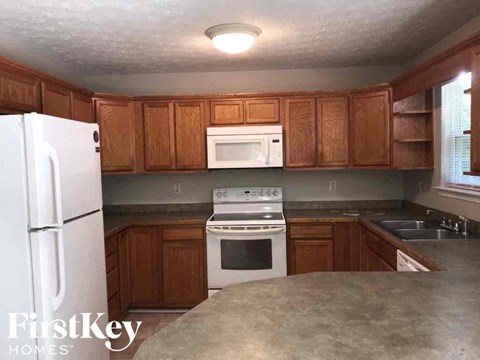 A kitchen with wooden cabinets and a white refrigerator.