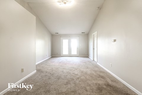an empty living room with white walls and carpet