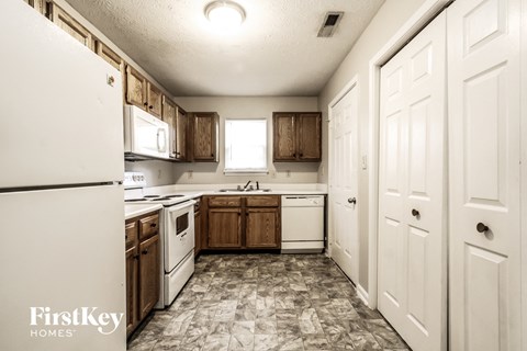 a kitchen with white appliances and wooden cabinets