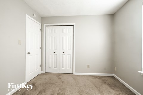 a bedroom with two doors and a carpeted floor