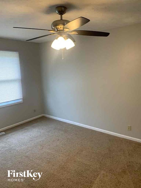 a bedroom with a ceiling fan and a window