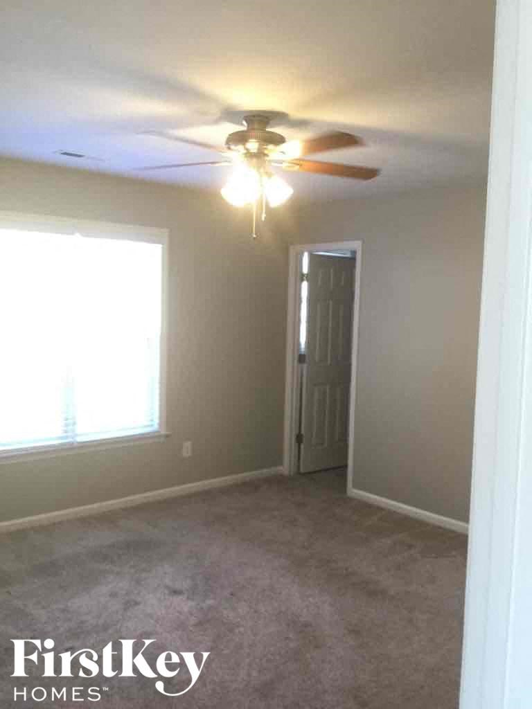 an empty room with a ceiling fan and a door to a closet