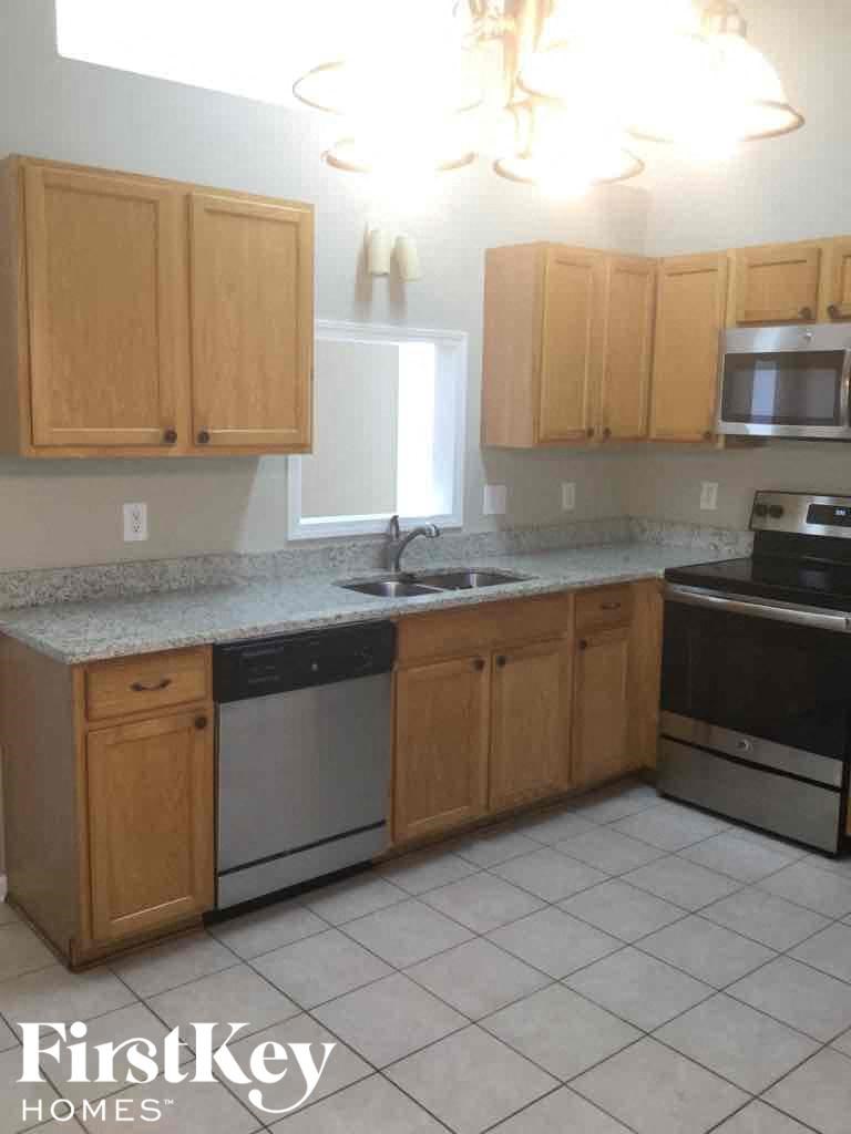 an empty kitchen with wooden cabinets and a sink