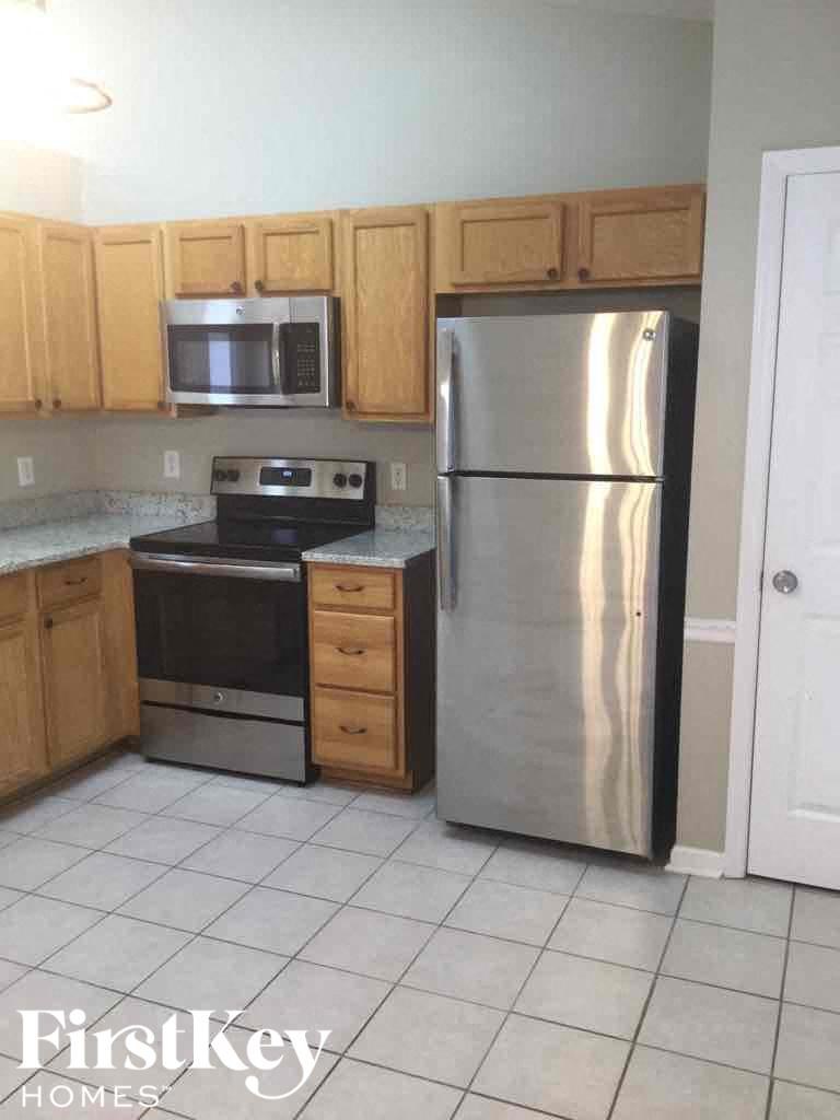 a kitchen with wooden cabinets and a stainless steel refrigerator