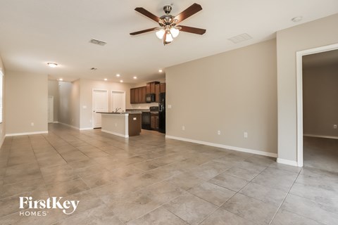 A spacious room with a ceiling fan and lighting fixtures.
