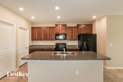 A kitchen with brown cabinets and a granite countertop.