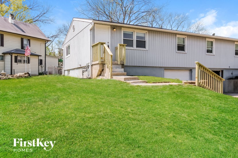 A house with a flag on the left and a garage on the right.