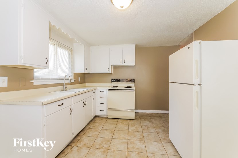A kitchen with white cabinets and appliances.