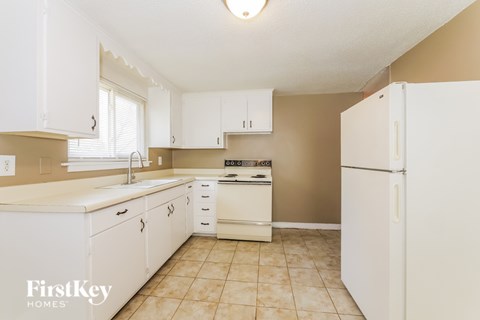 A kitchen with white cabinets and appliances.