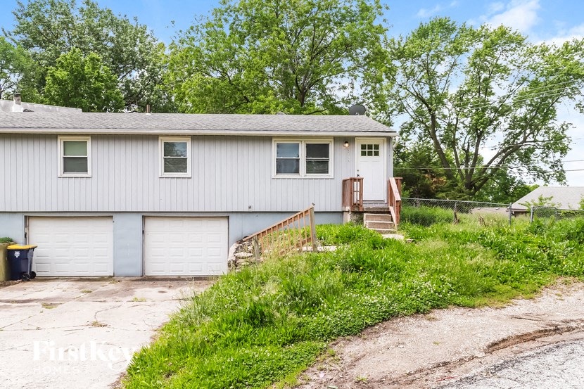 a white house with two garage doors and a driveway
