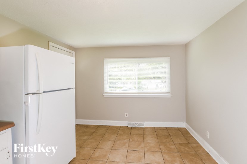 an empty kitchen with a refrigerator and a window
