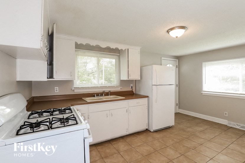 a kitchen with a stove and a sink and a refrigerator