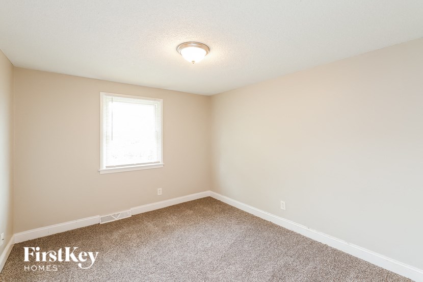 a bedroom with a carpeted floor and a window