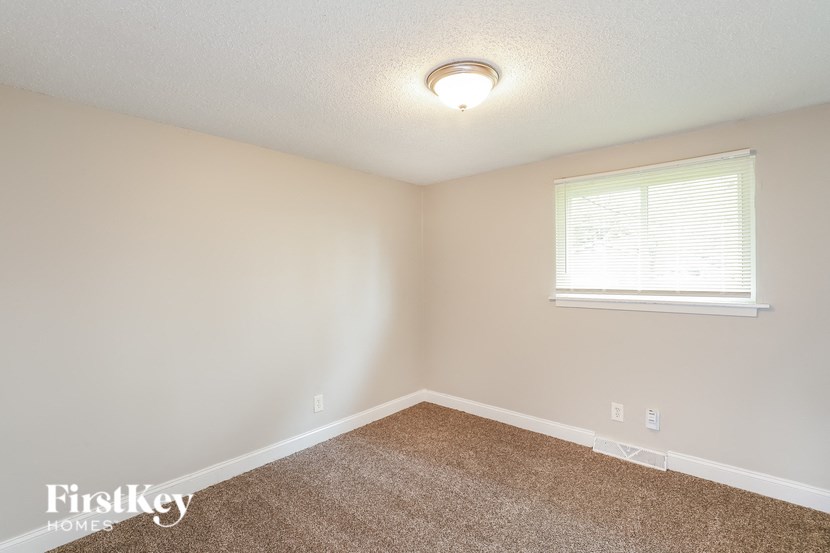 a bedroom with a carpeted floor and a window