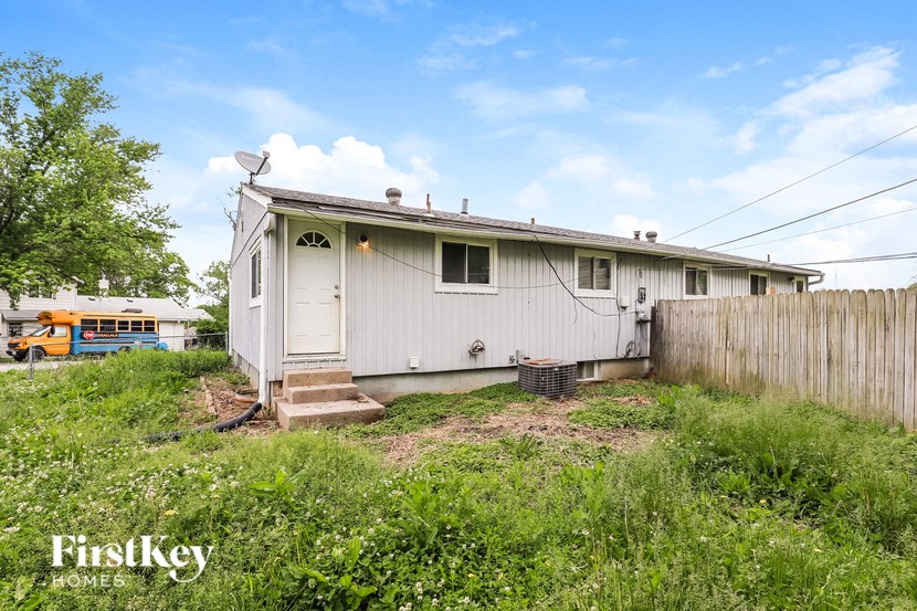 a small white house with a yard and a fence