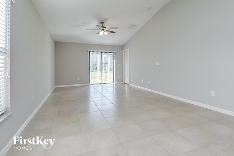A spacious room with a ceiling fan and tiled flooring.