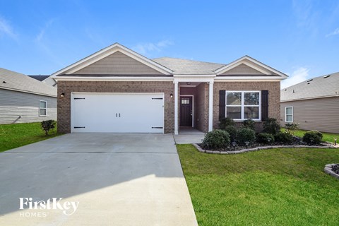 A house with a garage and a driveway in front of it.