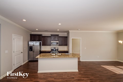 A kitchen with a granite countertop and a refrigerator.