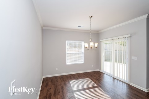 A well-lit room with wooden floors and a chandelier.