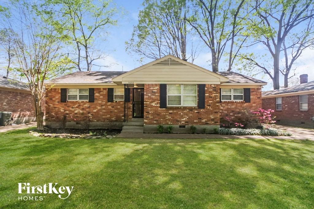 A brick house with a green lawn in front.