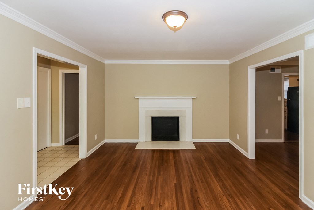 A living room with a fireplace and wood floors.