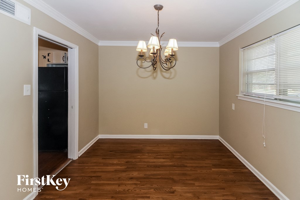 A room with wooden floors and a chandelier hanging from the ceiling.