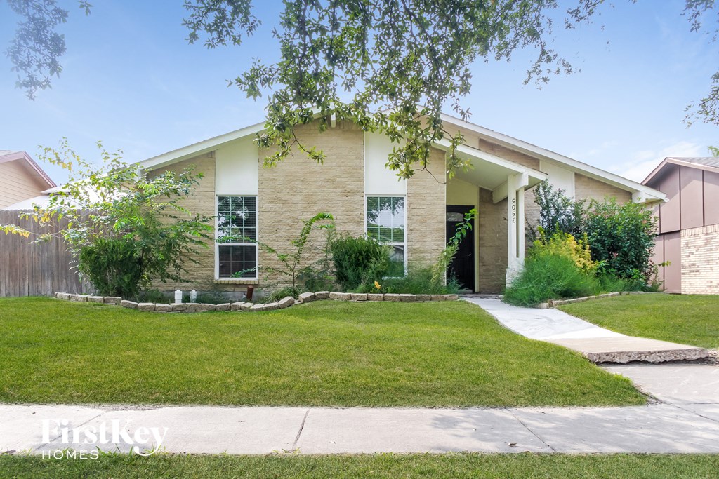 a house with a lawn and a sidewalk in front of it