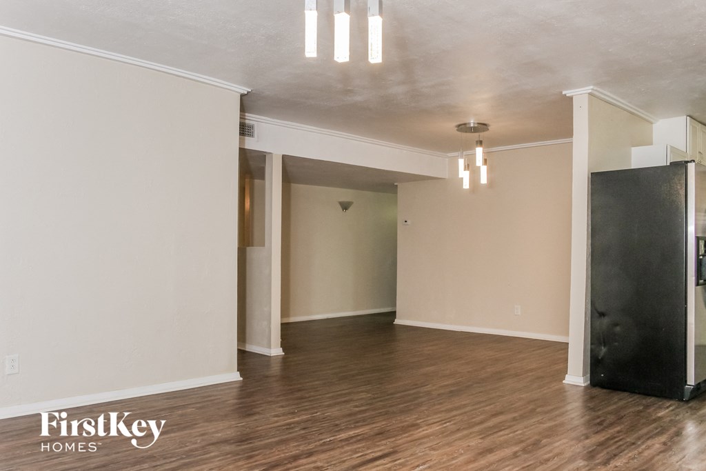 an empty living room with wood floors and white walls