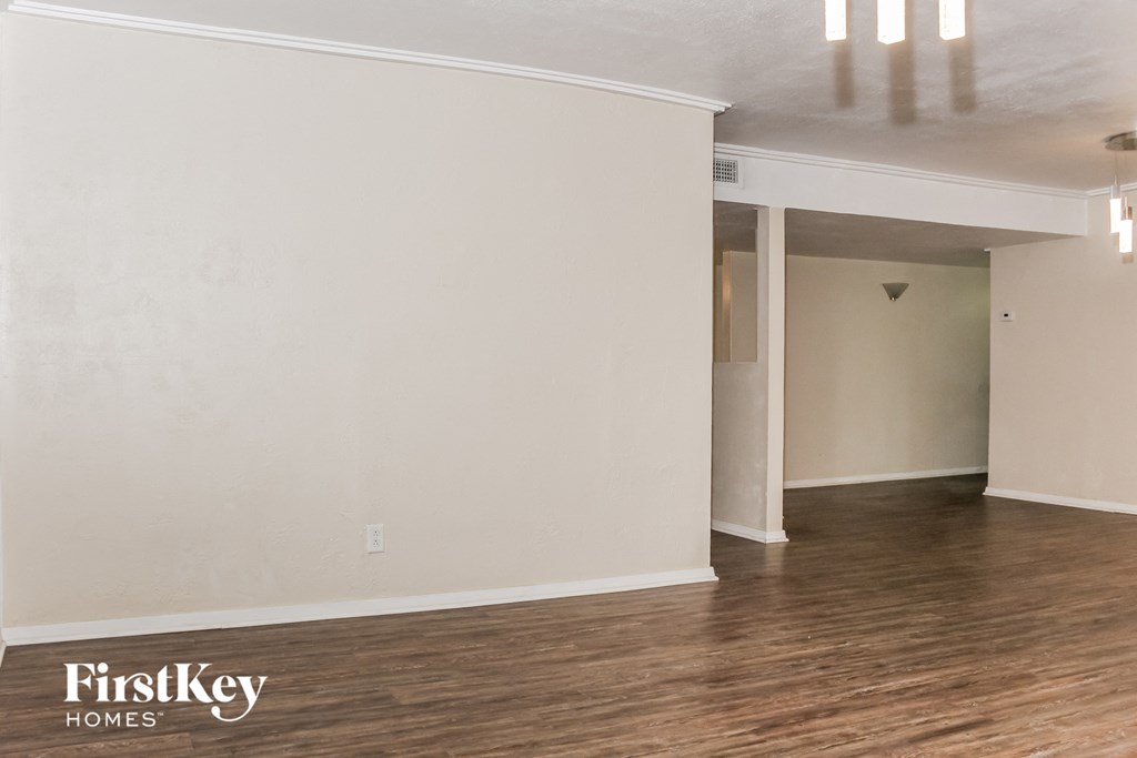 an empty living room with white walls and wood floors