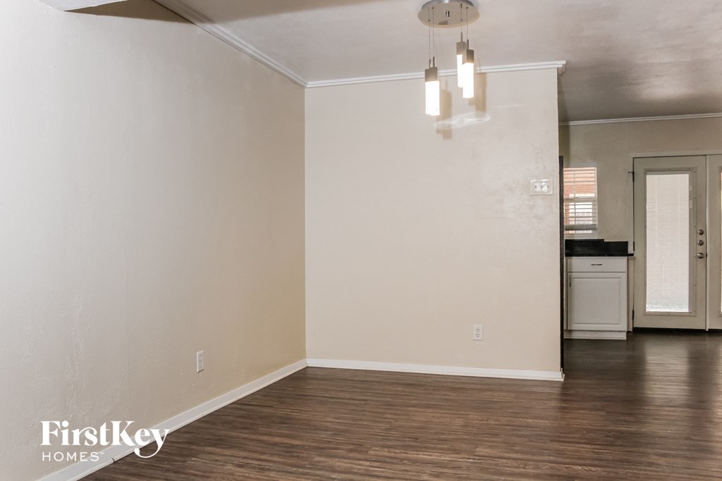 an empty living room with white walls and wood floors