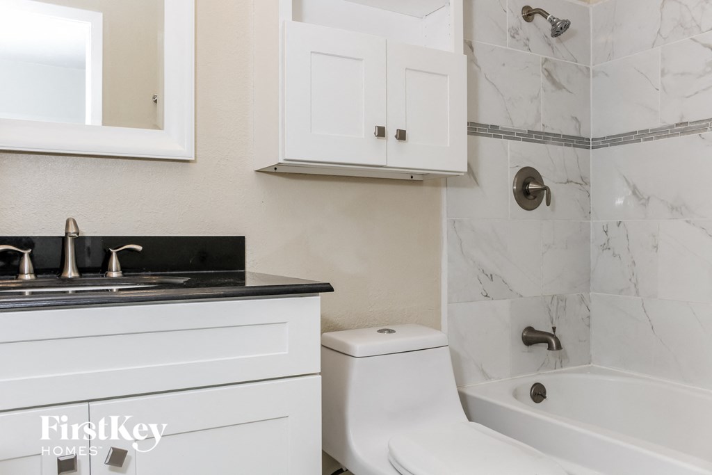 a white bathroom with a tub and sink and a toilet