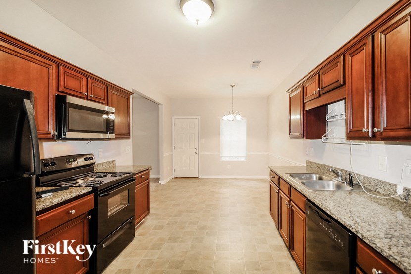 a kitchen with wood cabinets and black appliances and granite counter tops