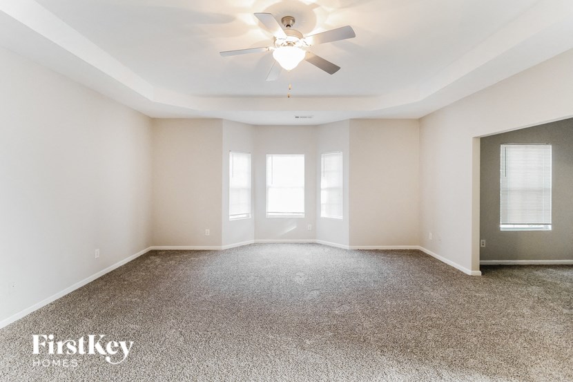 the living room of an empty house with a ceiling fan