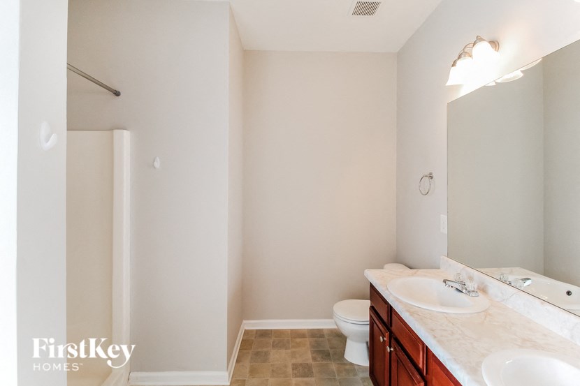 a bathroom with two sinks and a toilet and a large mirror