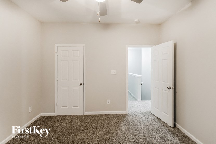 a bedroom with two white doors and a carpeted floor