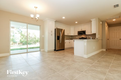 A spacious kitchen with a refrigerator, microwave, and oven.