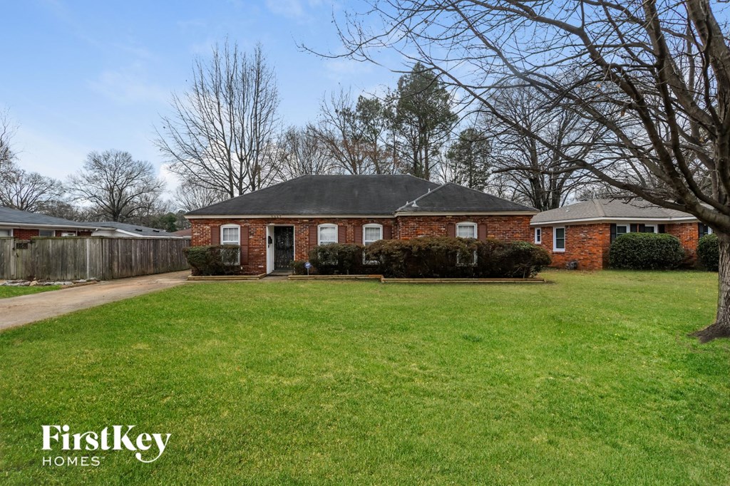 A brick house with a lawn in front of it.